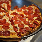A pepperoni pizza with one slice gone made by Pizza Junction