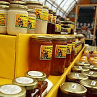 Jars lining a display stand filled with different types of honey at Ackroyds Honey