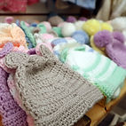 stacks of handmade knitted baby hats by Bizzie's Beehive