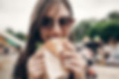 Woman at the St. Jacobs Market enjoying a handcrafted burger from one of our amazing food vendors.