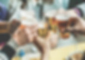 group of hands in a cheers all holder beer steins at a table 