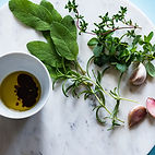 Fresh herbs displayed on a white marble board by Herb Crafters