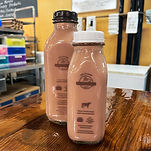 2 bottles of chocolate milk on the counter of Meadow song Acres Booth