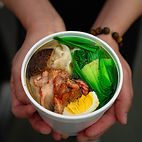 an appitizing bowl of wonton soup topped with an egg, meat and bok choy from Noi Kitchen