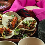 Authentic mexican tacos sitting atop fresh greens at Chirizos La Abuela