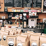 A displayed filled with freshly ground coffee on a coffee shop counter at Full of Beans Coffee Bar